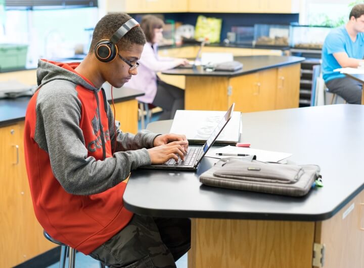student working on laptop with headphones