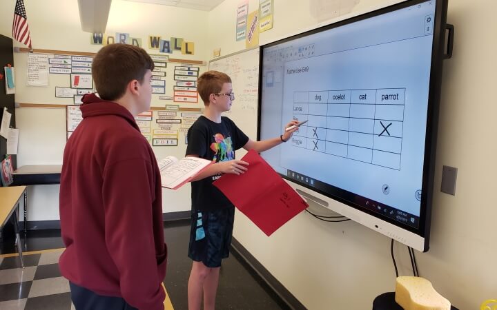 student using smartboard interactive panel in math class