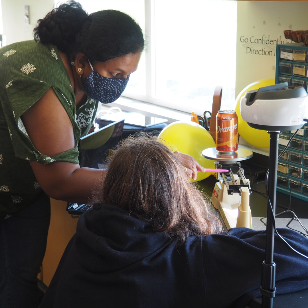 female teacher helping a student with measurements